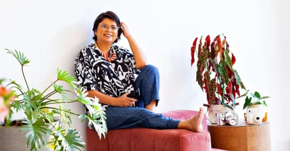 Andreia, fundadora da Ideia Negocios do Bem, mulher com calça e blusa estampada sorrindo para ilustrar o consumo consciente